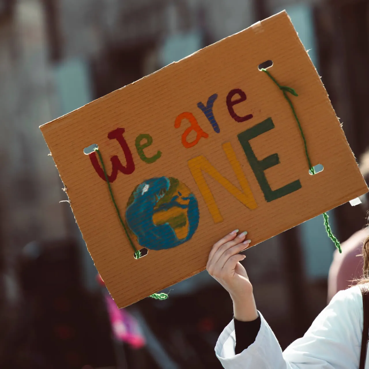 A Person holding a banner "we are one"